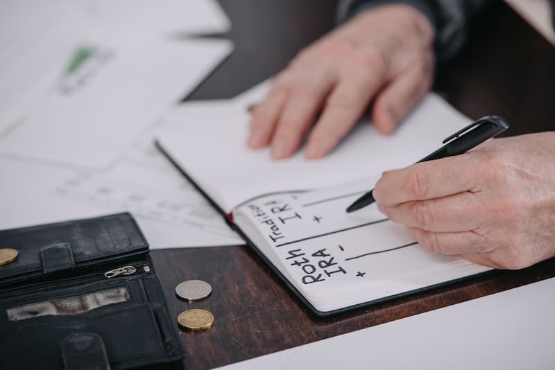 Woman writing out the differences between retirement accounts.