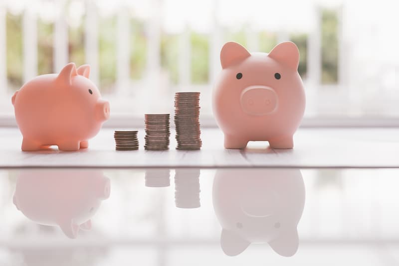 Two piggy banks, representing multiple retirement accounts.