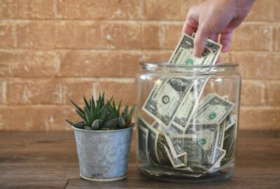 Person putting money into a clear jar