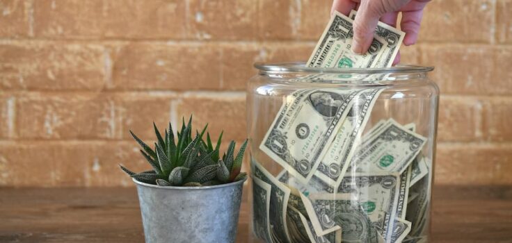 Person putting money into a clear jar