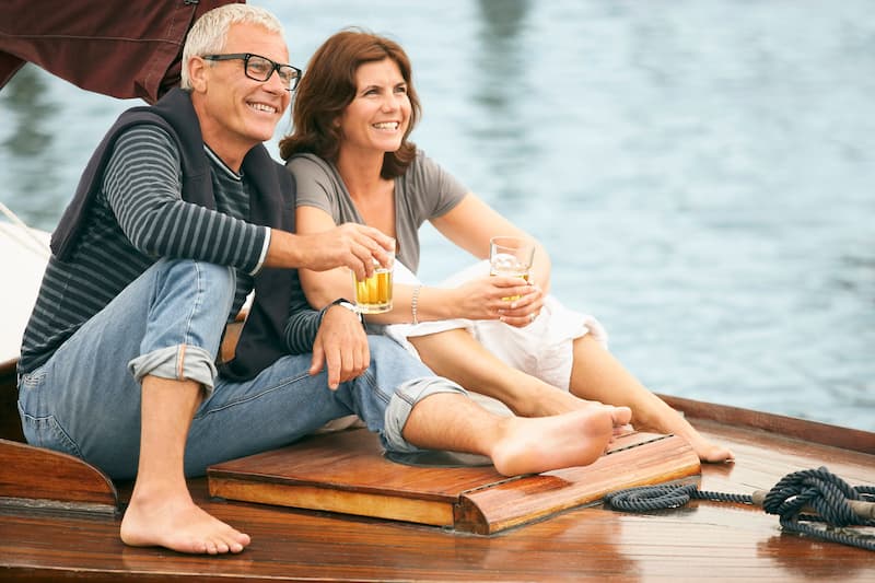 A couple sitting on a boat enjoying retirement life.