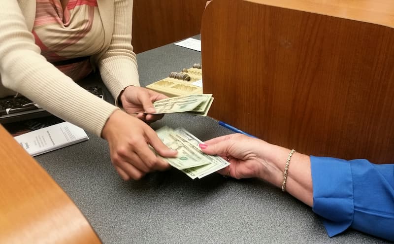 Bank teller handing money over to customer.