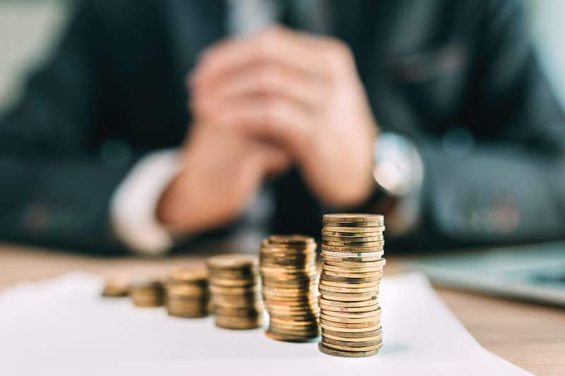 Financial advisor with stack of coins in front of him.