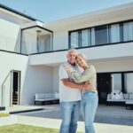 Senior couple standing in front of their Florida home after getting a reverse mortgage.