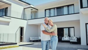 Senior couple standing in front of their Florida home after getting a reverse mortgage.