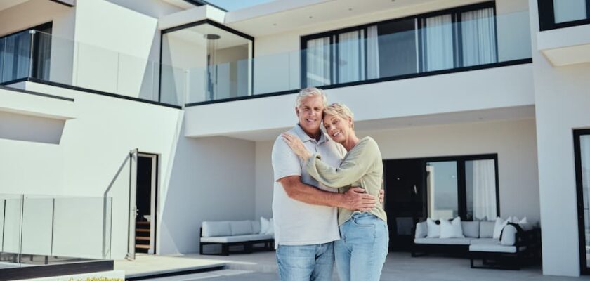 Senior couple standing in front of their Florida home after getting a reverse mortgage.