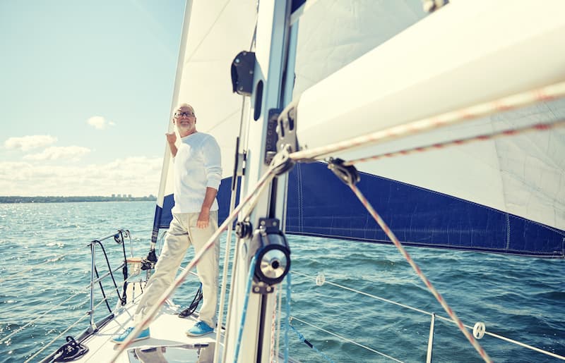 Successful retiree standing on his sale boat.